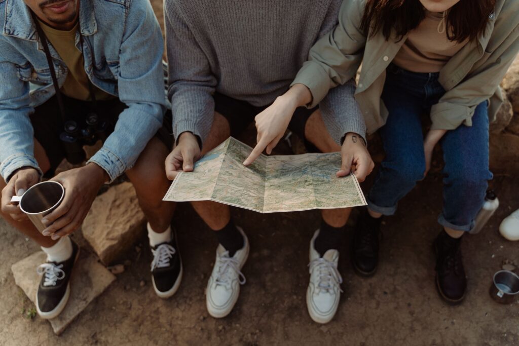 pexels photo 9943267 9943267 Group of friends sitting together, exploring a map for their next adventure, creating exciting travel plans.